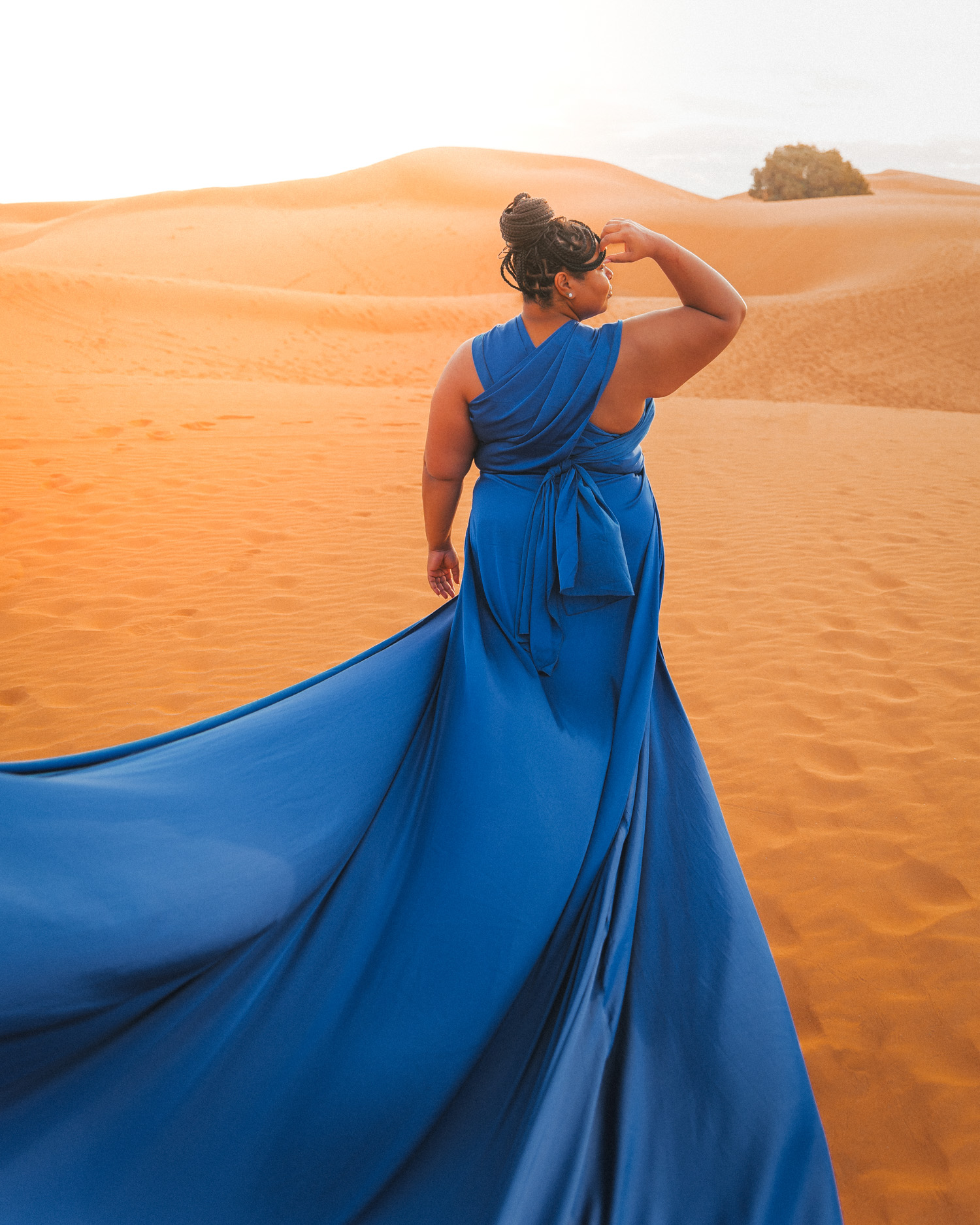 Sunrise in the Sahara, Morocco; woman in a blue flying dress