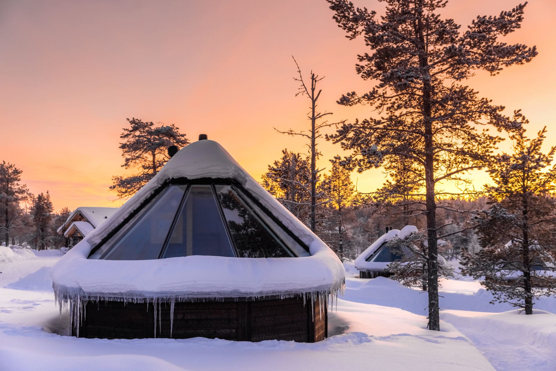 Lapland winter cabin at sunset; Wilderness Hotel Muotka near Ivalo, Finland in the Arctic Circle